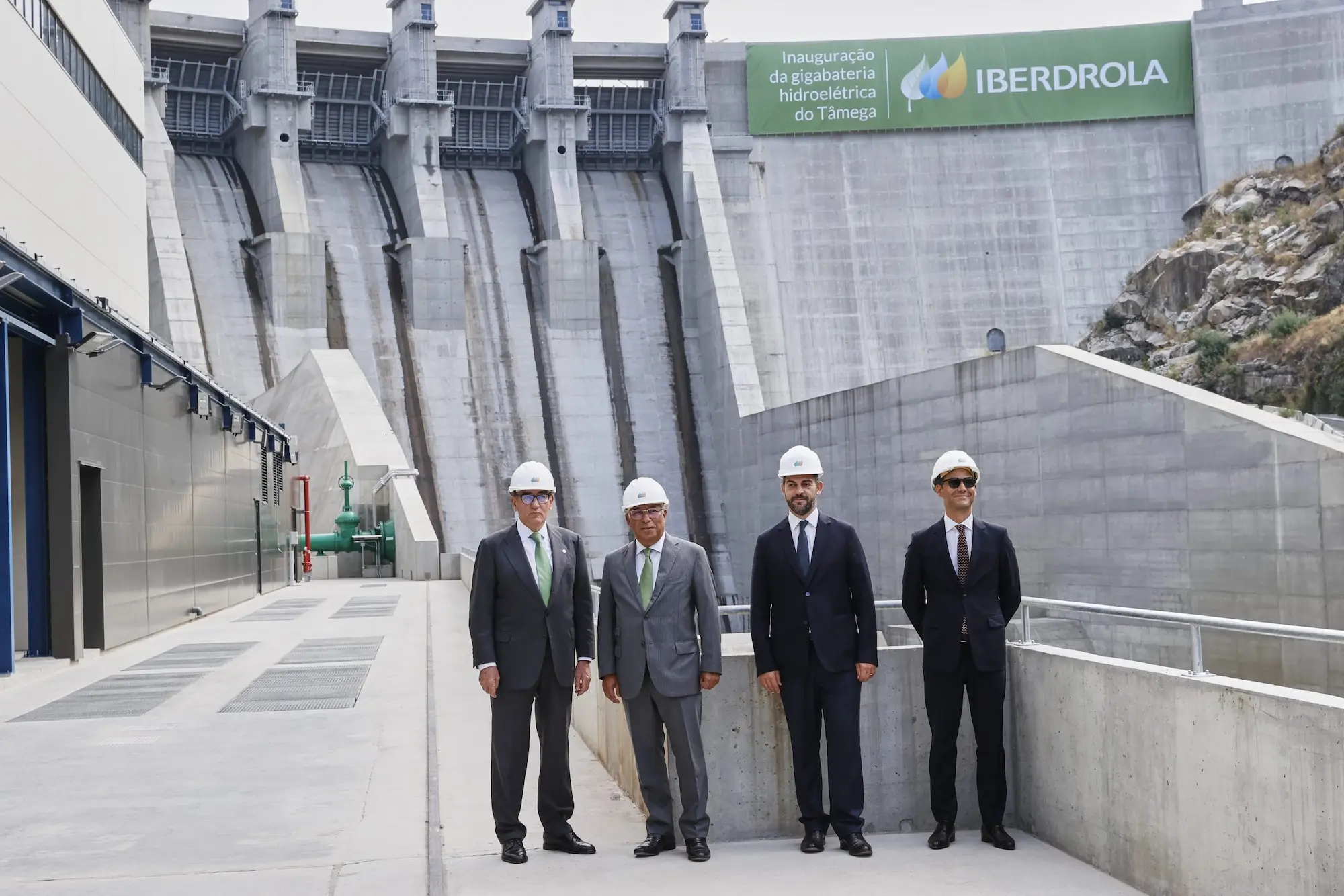 Cuatro miembros de Iberdrola con traje y cascos de obra posan en la inauguración de la Gigabatería del Támega en Portugal